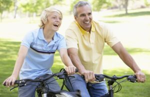 Man-Wearing-Compression-Stockings-Bike-Riding-With-Son