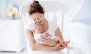 New-Mother-Holding-Baby-In-Rocking-Chair