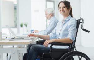Smiling-Woman-In-Wheelchair-At-Desk