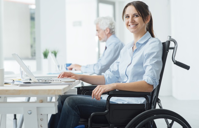 Smiling-Woman-In-Wheelchair-At-Desk