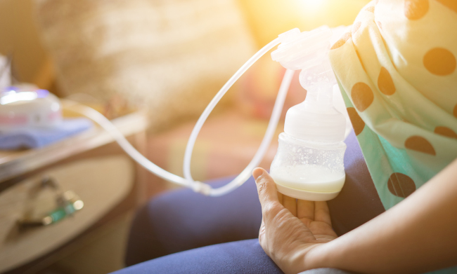 Woman using free breast pump from insurance provider